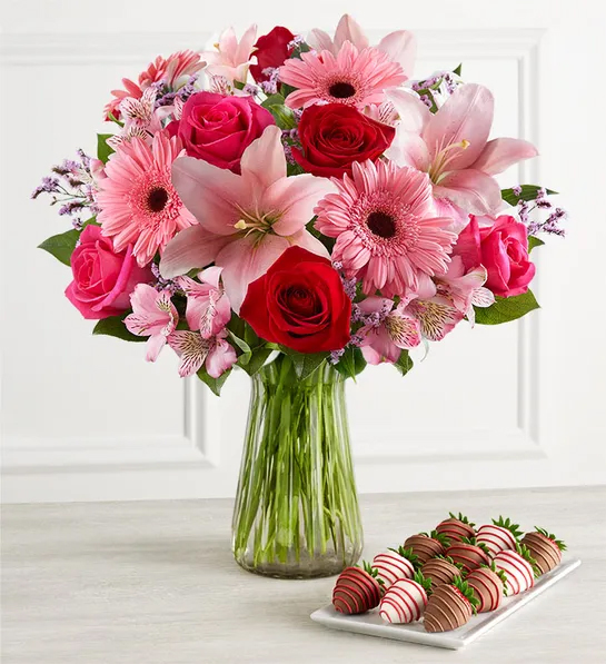 Bouquet of flowers next to a plate of chocolate covered strawberries