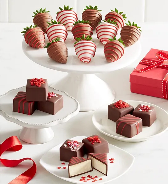 Chocolate covered strawberries and petit fours on plates